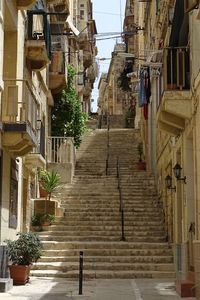 Low angle view of staircase amidst buildings in city