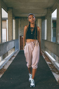 Portrait of woman standing against building