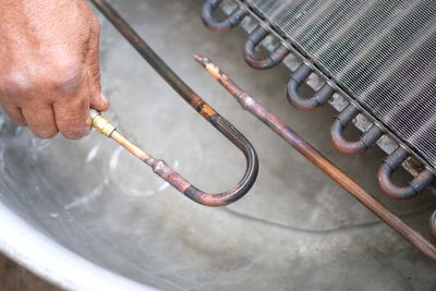 Cropped hand of man repairing metal