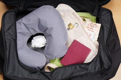 High angle view of padlock and neck pillow in suitcase