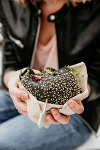 Midsection of man holding burger