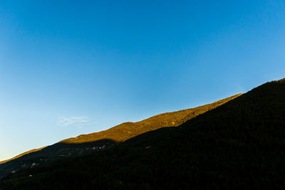 Low angle view of mountain against blue sky