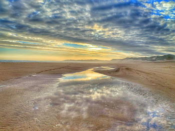 Scenic view of beach against sky during sunset