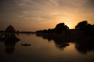 Canal amidst buildings against sky during sunset