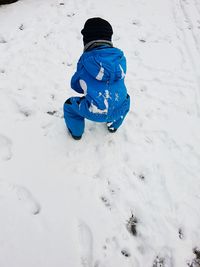 High angle view of boy playing on snow field