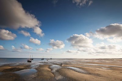 Scenic view of beach against cloudy sky