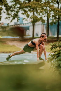 Young woman exercising outdoors in park.