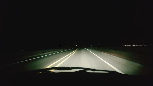 Cars on road against clear sky at night