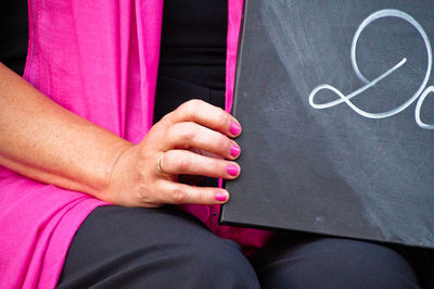 Midsection of woman holding slate