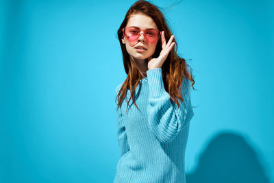 Portrait of smiling woman against blue background