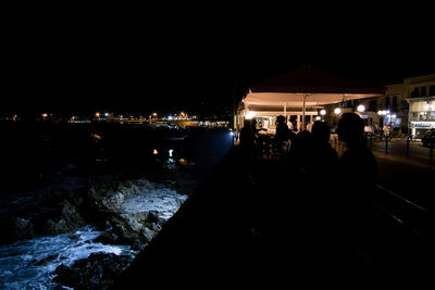 People in illuminated city at night