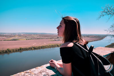 Woman looking at camera against sky