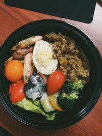 Directly above shot of various food in black bowl on table