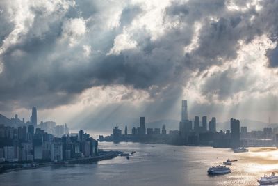 High angle view of cloudy sky over city and boats moving in sea