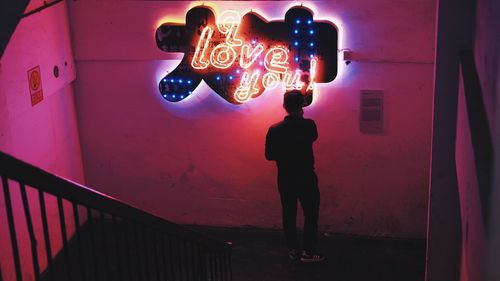 Full length of man standing on illuminated text