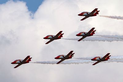 Low angle view of fighter planes flying against sky