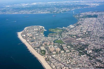 High angle view of cityscape by sea against sky