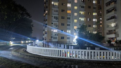 Illuminated buildings by street in city at night