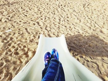 Low section of man relaxing on sand
