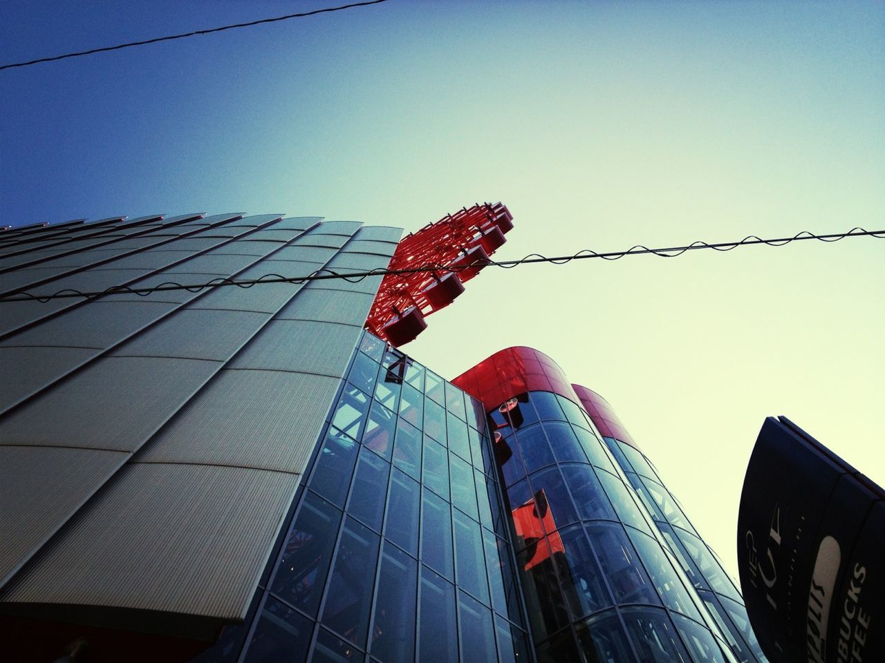 low angle view, clear sky, building exterior, architecture, built structure, city, skyscraper, tall - high, red, modern, sky, office building, day, tower, outdoors, development, american flag, city life, no people, construction site