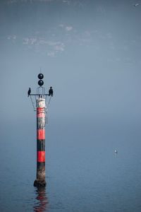 Lighthouse by sea against sky