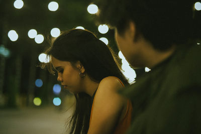 Side view of woman looking away at night