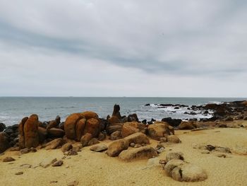 Rocks on beach against sky