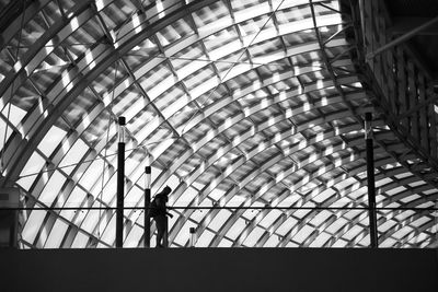 Low angle view of silhouette people walking in modern building