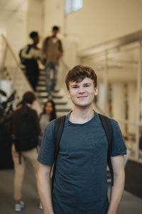 Portrait of smiling young male student standing in university