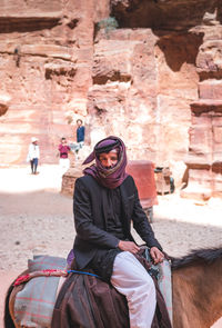 Full length of man riding motorcycle on rock formation