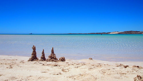 Scenic view of beach against clear blue sky