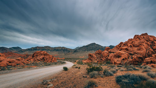 Scenic view of road passing by rock formations against sky