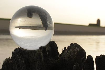 Close-up of crystal ball on rock at beach