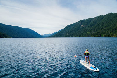 Person on lake against sky