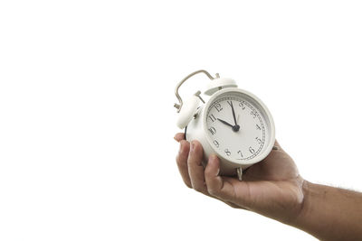 Hand holding clock against white background