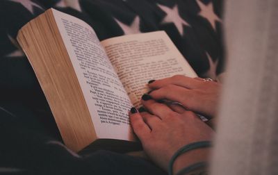 Close-up of human hand on book