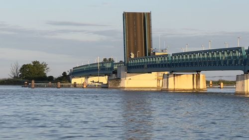 Bridge over river against sky during sunset