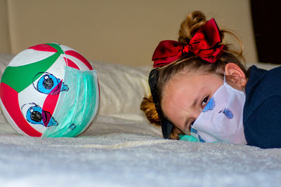 Portrait of girl lying down on bed at home