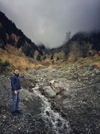 Full length of man standing on mountain against sky