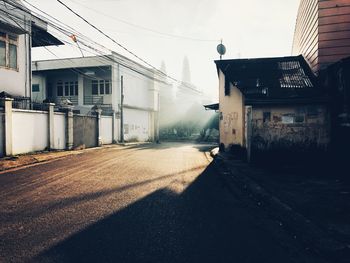 Empty street amidst buildings in city against sky