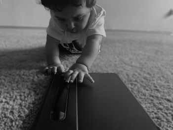 Cute baby girl touching digital tablet on floor at home