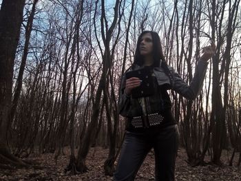 Portrait of young woman standing in forest