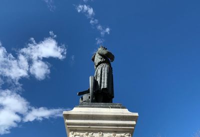 Low angle view of statue against blue sky