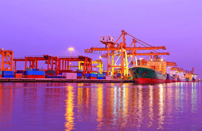 Cranes at illuminated commercial dock at night