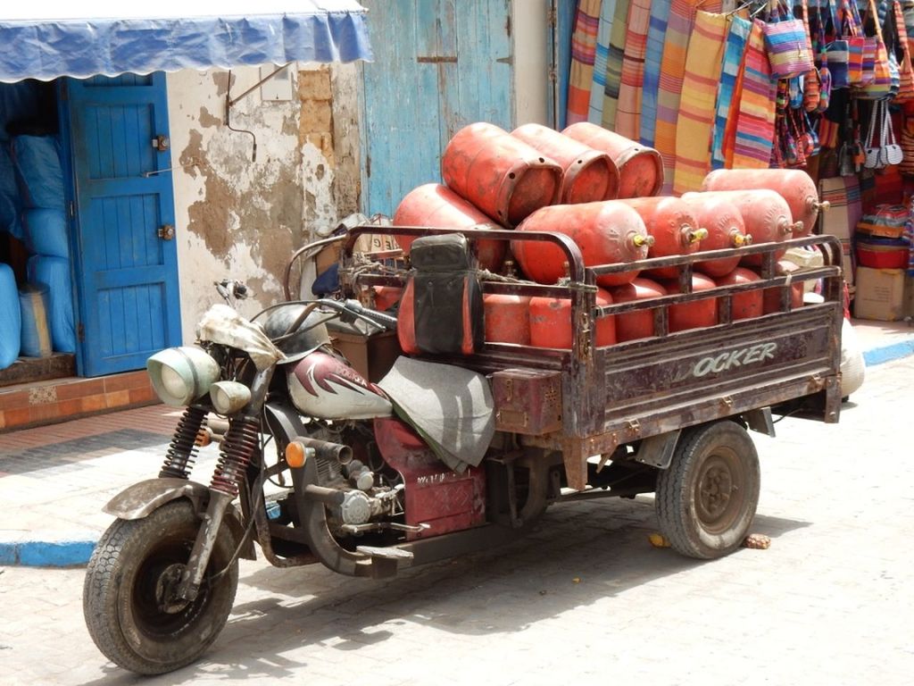 transportation, mode of transportation, vehicle, rickshaw, street, city, land vehicle, architecture, day, travel, road, cart, sunlight, outdoors, motor vehicle, wheel, building exterior, no people