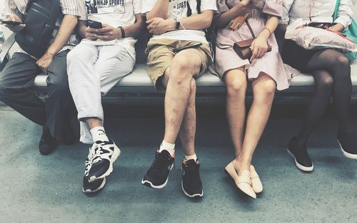 Low section of people sitting on bench in waiting room