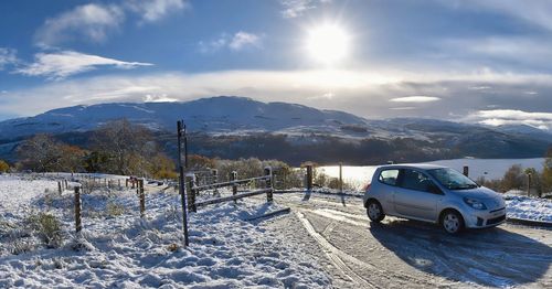 Car on snow covered mountain against sky