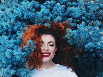 Portrait of smiling young woman against plants