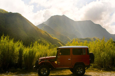 Vintage car on field against mountains