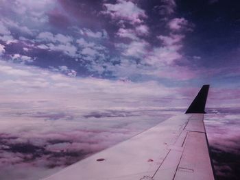 Cropped image of airplane flying over clouds